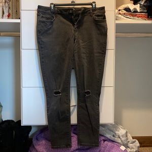 Dark gray skinny jeans with pockets and ripped holes in knees